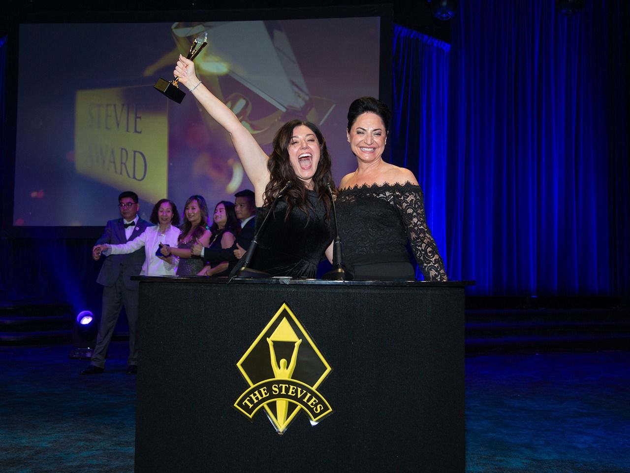 Stevie Award winners celebrating on stage at the awards ceremony